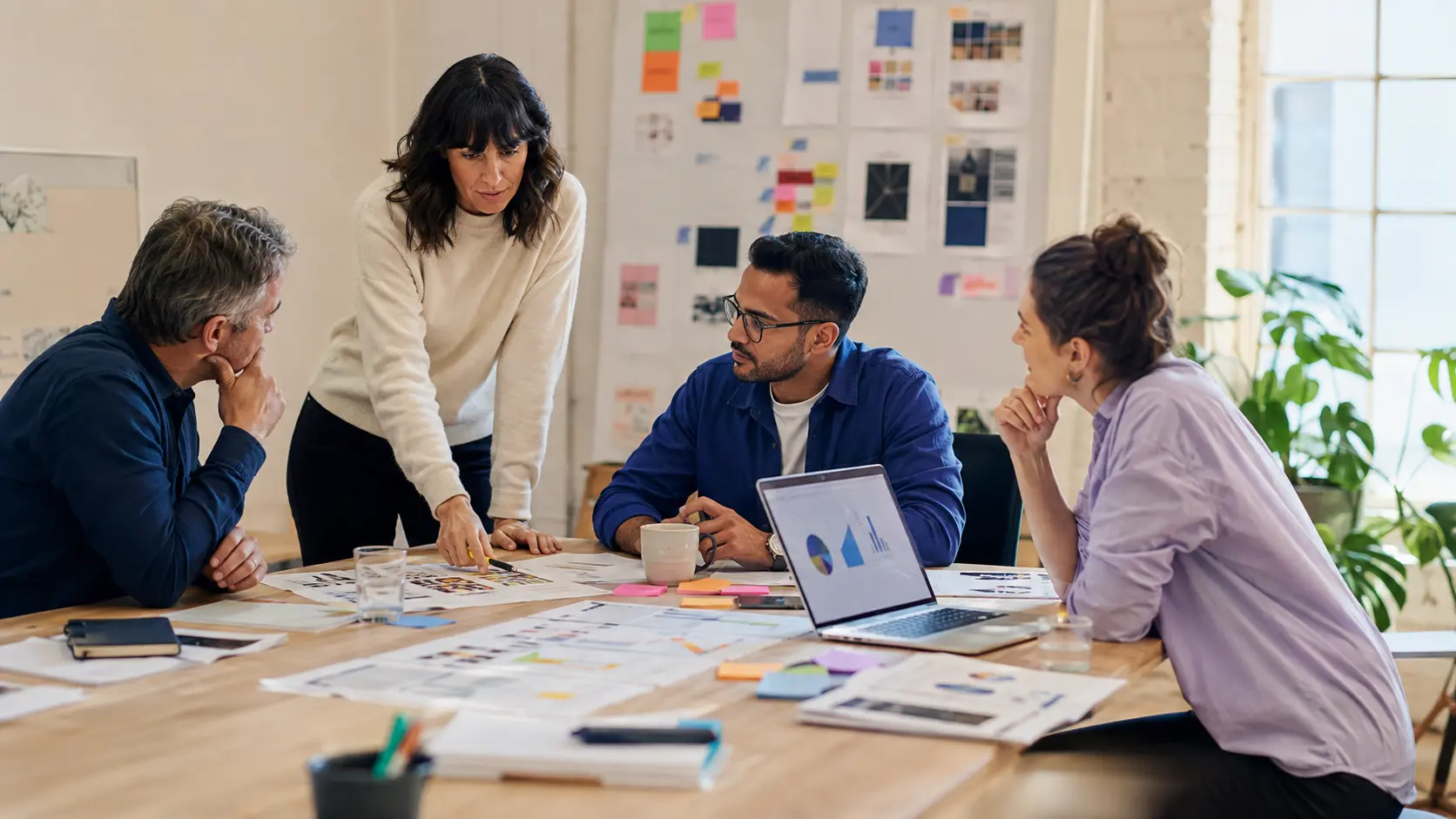 Growth strategists reviewing campaign ideas and printed performance charts