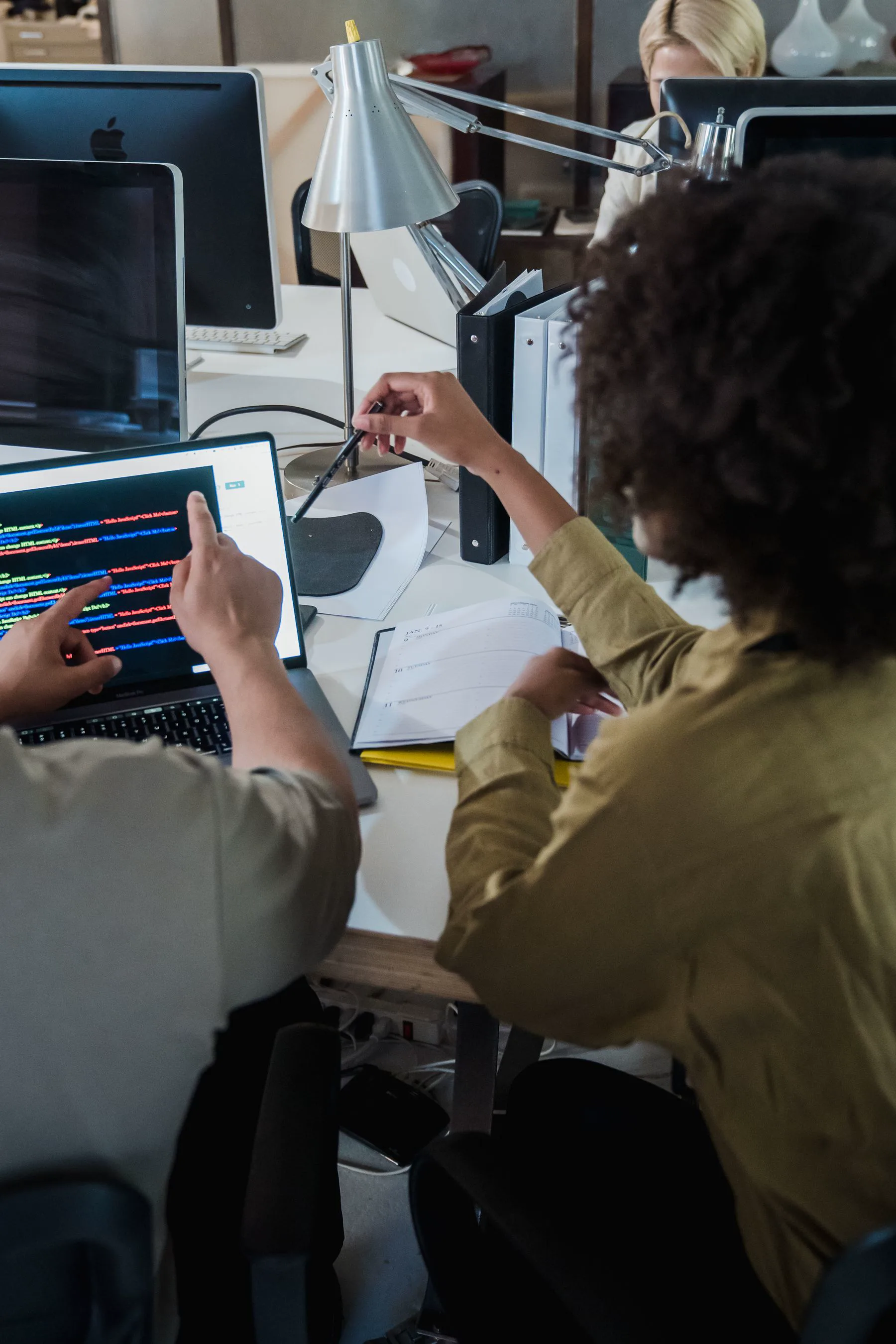 Software developers reviewing code together on a laptop